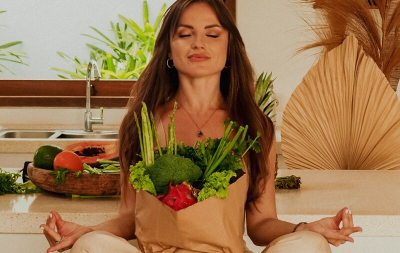 Kate Guner sitting in a kitchen with a bag of vegetables