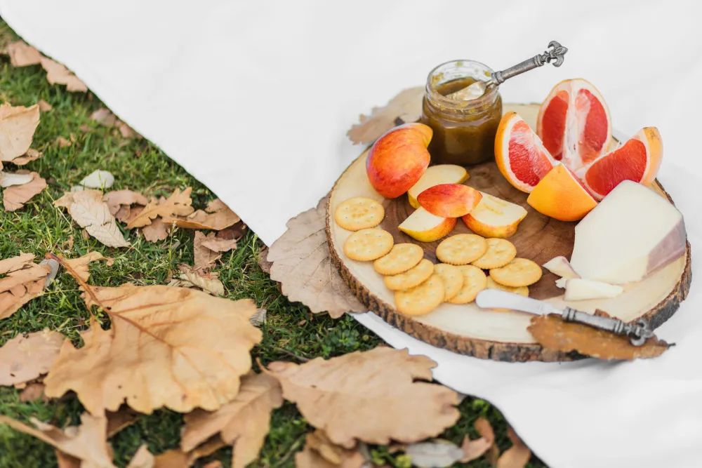 healthy road trip snacks: a plate of fruit and crackers on a wood surface